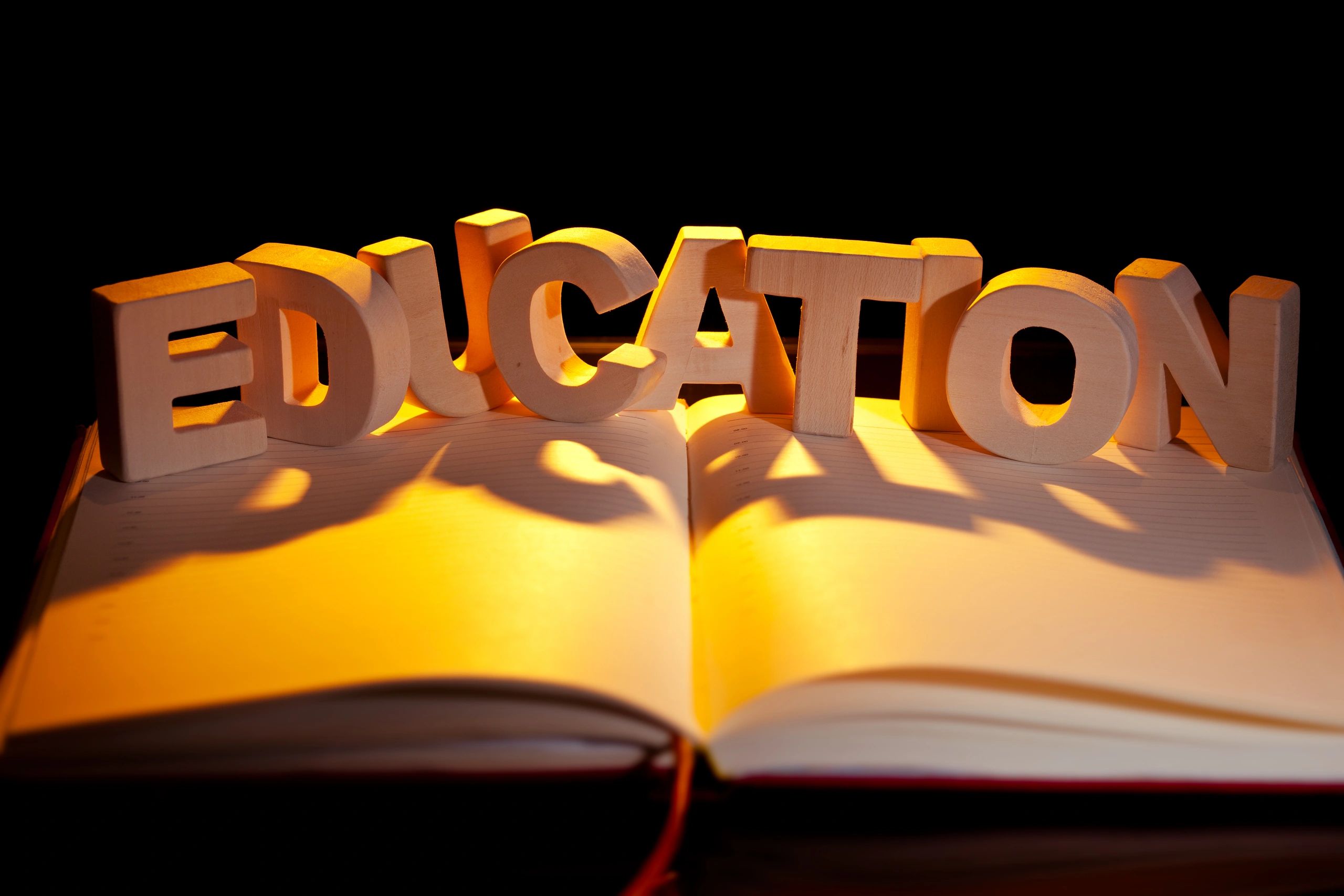Open book with the word Education on a dark background
